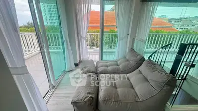 Spacious living room with cozy seating and balcony view in modern apartment.