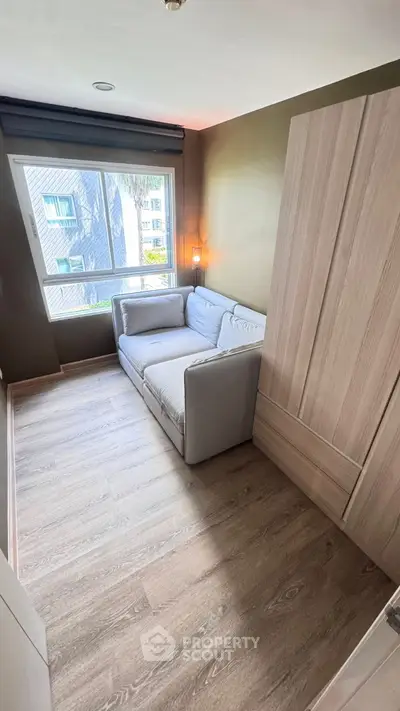 Cozy small living room with a modern sofa and large window view