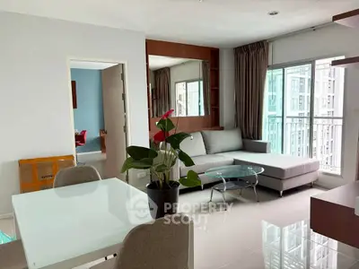 Modern living room with large windows and stylish furniture in a high-rise apartment.