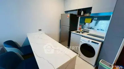 Modern kitchen with sleek appliances and marble countertop in stylish apartment.