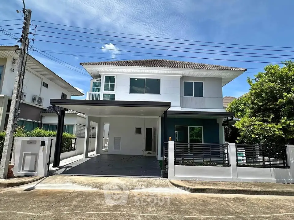 Modern two-story house with spacious driveway and sleek design in a suburban neighborhood.