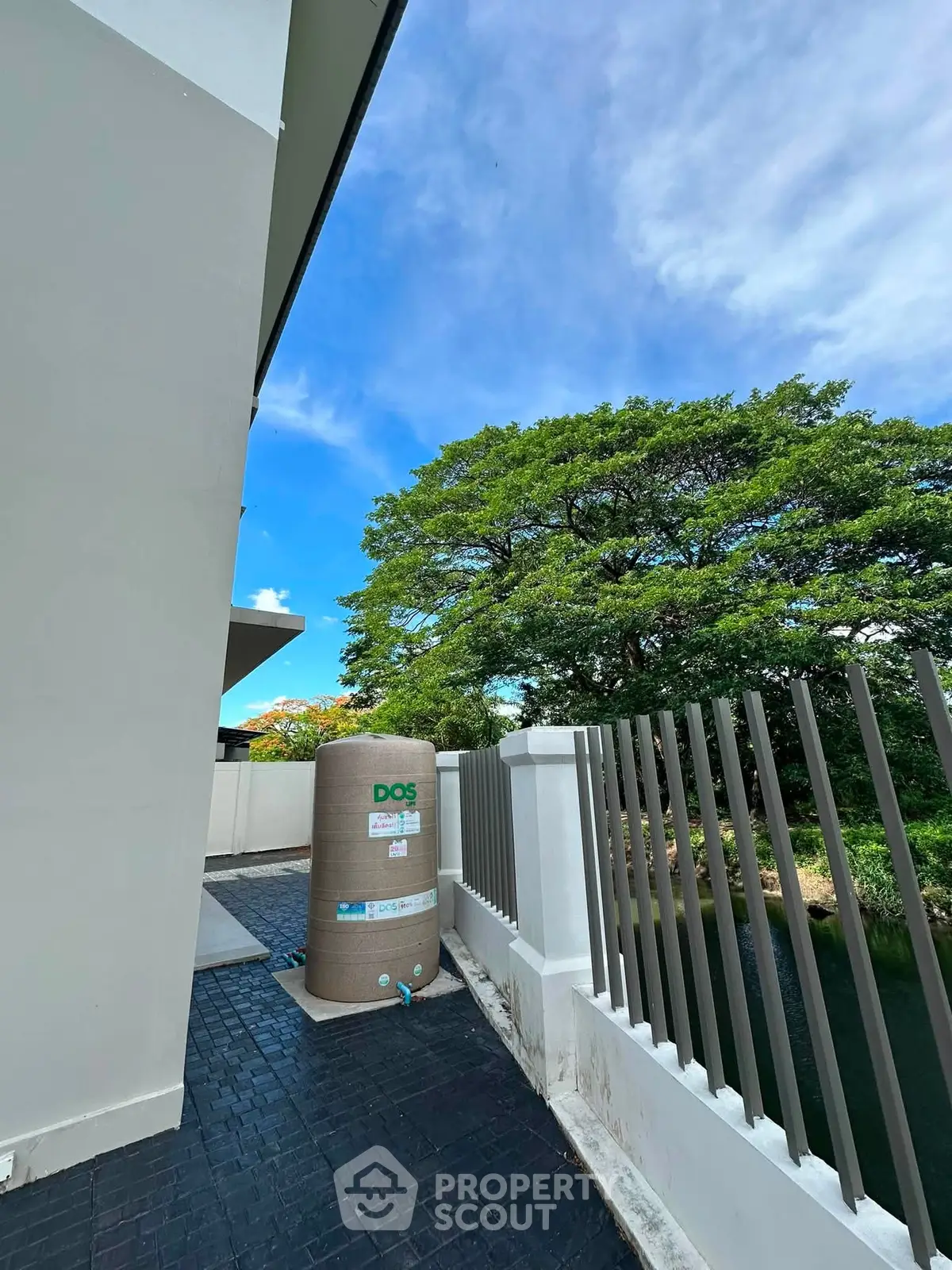 Modern exterior with water tank and lush greenery view