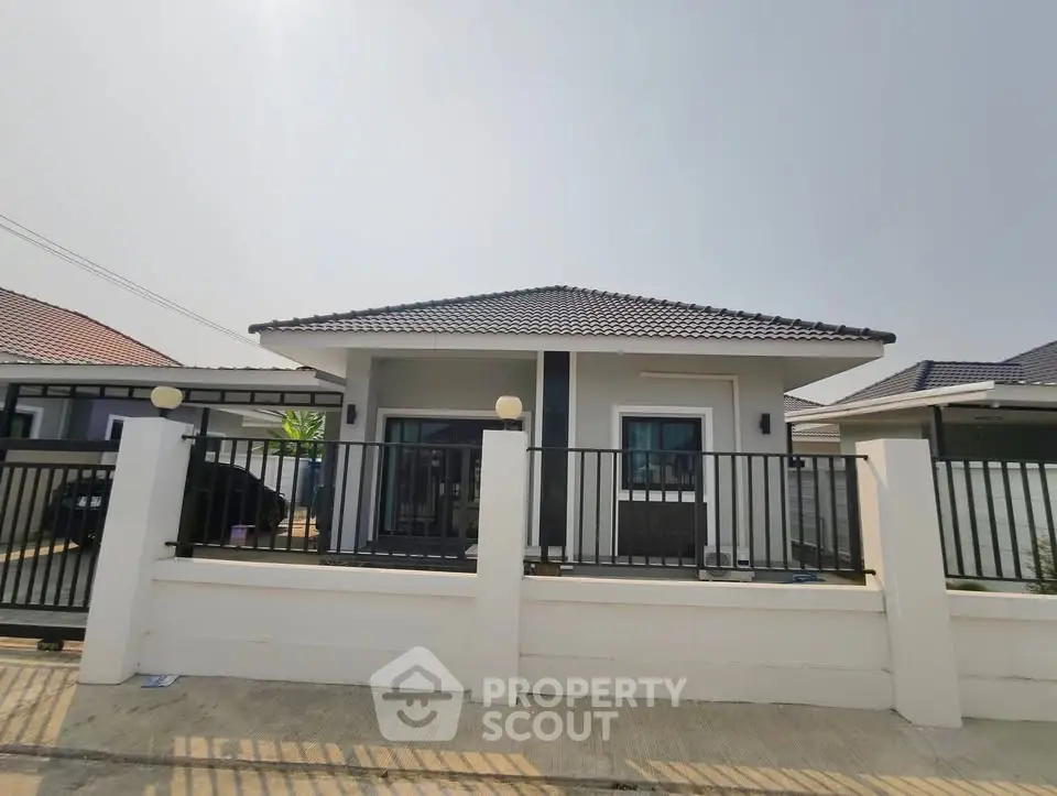 Charming single-story house with modern design and fenced front yard in a serene neighborhood.