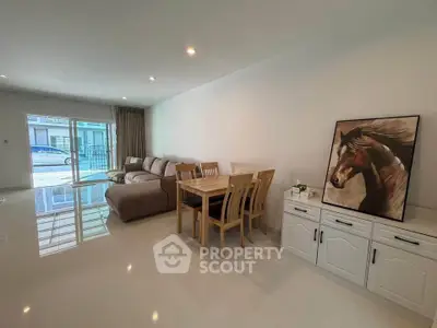 Spacious living room with modern furniture and elegant decor, featuring a large window for natural light.