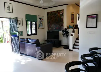 Stylish living room with leather sofa, modern art, and natural light in a contemporary home.