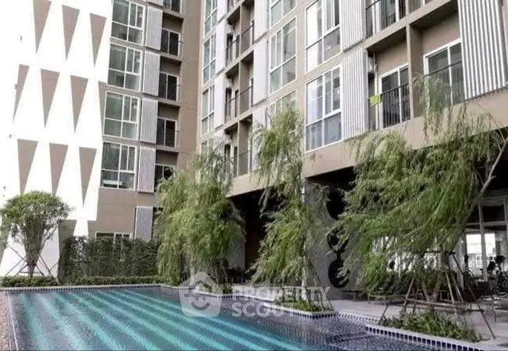 Modern apartment building with pool and lush greenery, perfect for urban living.