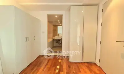 Spacious modern bathroom with sleek cabinetry and wooden flooring