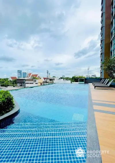 Luxurious rooftop pool with stunning city views in modern high-rise building.