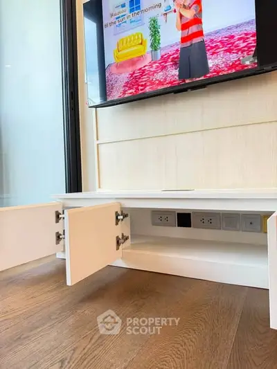 Modern living room with built-in TV cabinet and hardwood flooring