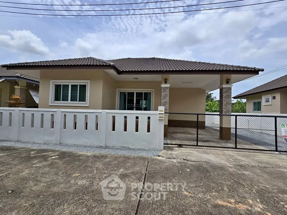 Charming single-story home with gated driveway and modern exterior design.