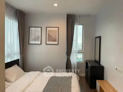 Modern bedroom with stylish decor and large windows offering natural light.