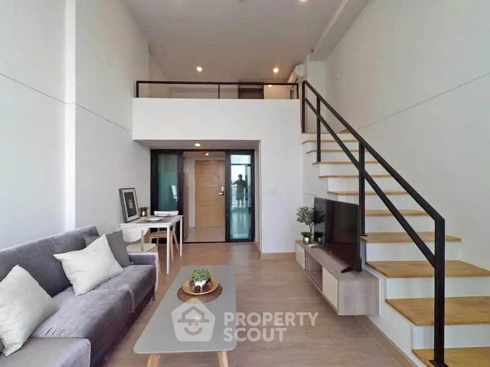 Modern loft-style living room with mezzanine and sleek staircase