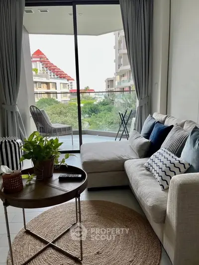 Stylish living room with cozy sofa and balcony view, perfect for relaxation and entertaining.