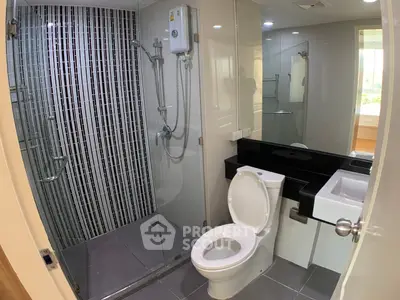 Modern bathroom with sleek shower and contemporary fixtures in a stylish apartment.