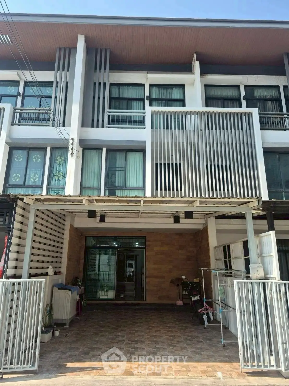 Modern townhouse exterior with sleek design and gated entrance, perfect for urban living.