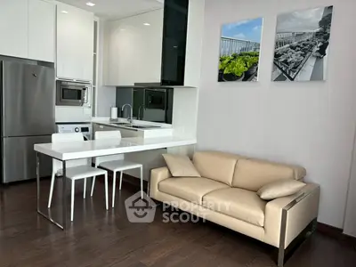 Modern kitchen and living area with sleek design and cozy beige sofa.