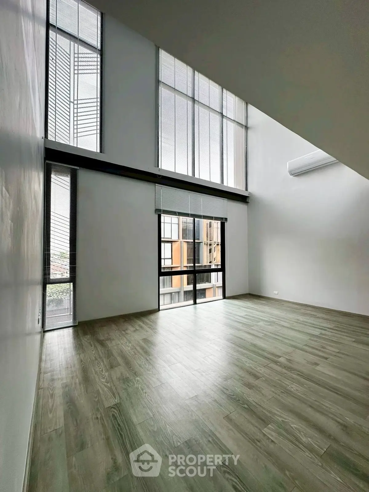Spacious modern living room with high ceilings and large windows for natural light.