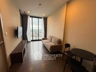 Modern living room with a cozy sofa and city view balcony in a high-rise apartment.