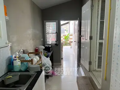 Cozy kitchen with open layout leading to a small balcony, featuring modern appliances and ample natural light.
