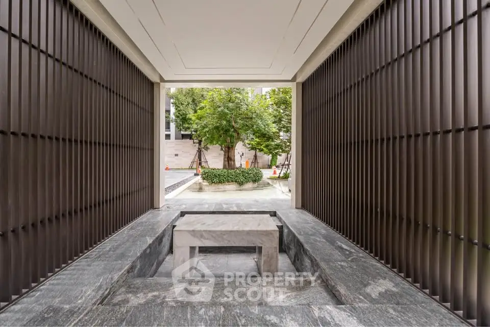 Elegant building entrance with modern design and lush greenery