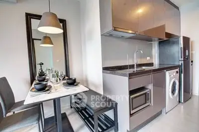 Modern kitchen with sleek cabinets, dining area, and built-in appliances in a stylish apartment.