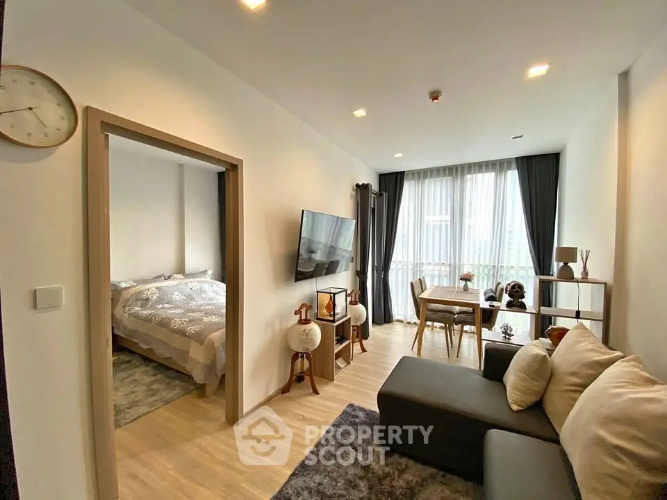 Modern living room with cozy bedroom, stylish decor, and natural light in contemporary apartment.