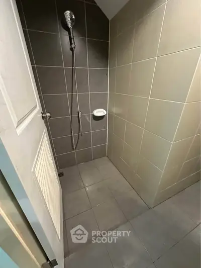 Modern bathroom with sleek gray tiles and a rainfall showerhead