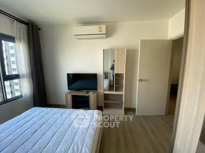 Modern bedroom with air conditioning, TV, and wooden furniture in a bright apartment.