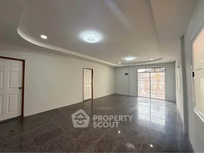 Spacious modern living room with sleek flooring and ample natural light