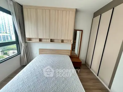 Modern bedroom with large window and built-in storage in urban apartment