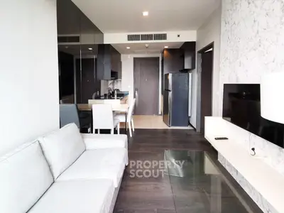Modern living room with sleek furniture and open kitchen layout in a stylish apartment.