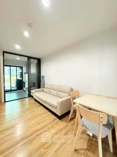 Modern living room with wooden flooring and cozy furniture in a bright apartment.