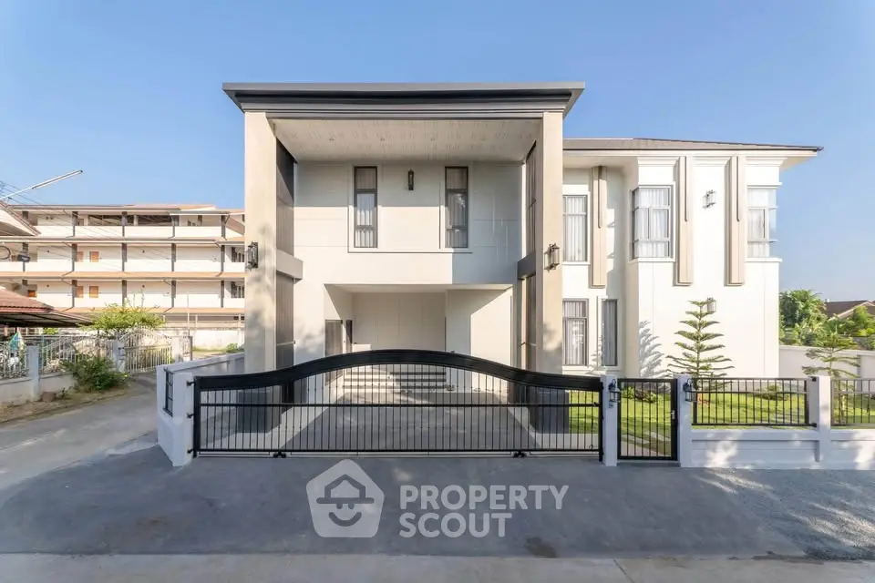 Modern two-story house with sleek design and gated entrance, showcasing contemporary architecture and spacious outdoor area.