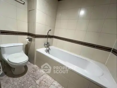 Modern bathroom with sleek bathtub and tiled walls, perfect for relaxation and comfort.