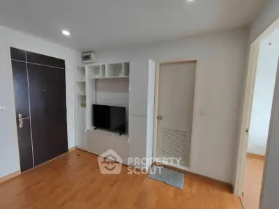 Modern apartment interior with wooden flooring and built-in TV unit