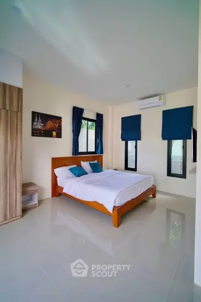 Modern bedroom with sleek design and natural light, featuring a comfortable bed and stylish decor.