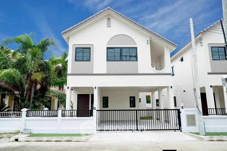 Stunning modern two-story house with gated entrance and lush palm trees, perfect for family living.