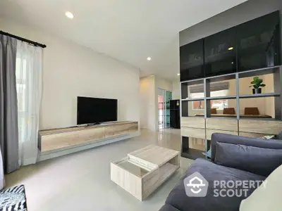 Modern living room with sleek furniture and large TV, perfect for relaxation and entertainment.