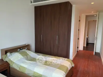 Modern bedroom with wooden flooring and spacious wardrobe in a cozy apartment.