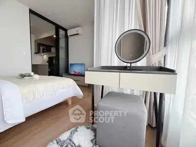 Modern bedroom with stylish vanity and open kitchen view in a bright apartment.