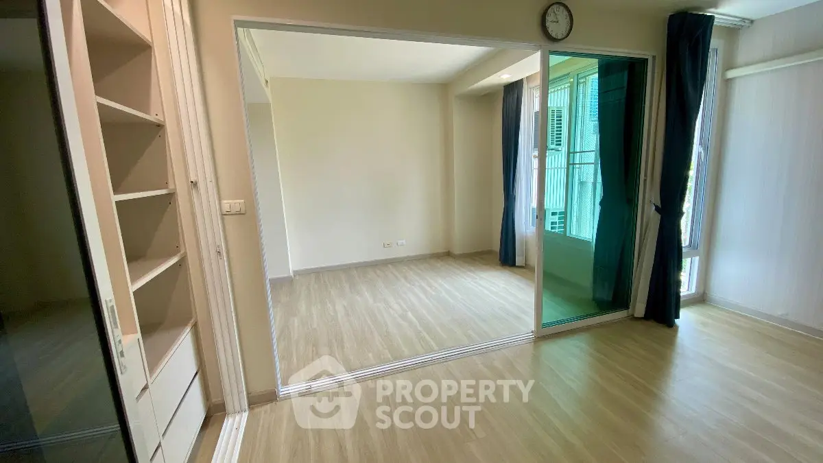 Spacious empty room with large mirror and wooden flooring, ideal for customization.
