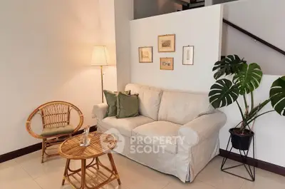 Cozy living room with stylish decor, featuring a comfortable sofa, elegant lamp, and chic wall art.