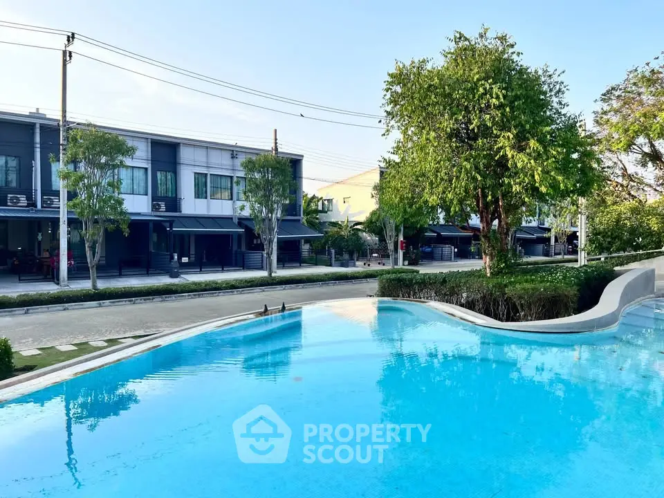 Luxurious residential complex with a pristine pool and modern townhouses, perfect for serene living.