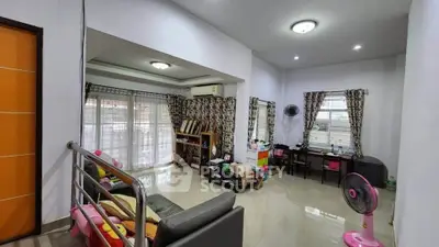 Spacious living room with modern decor and ample natural light.