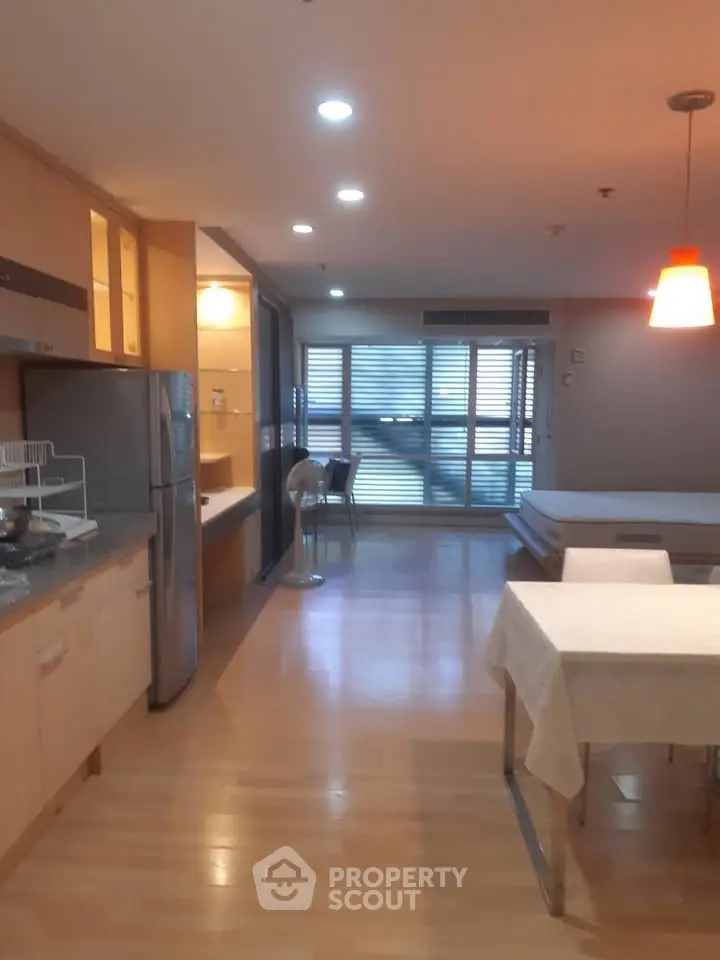 Spacious open-plan living area with modern kitchen and dining space, featuring sleek appliances and ample natural light.