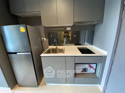 Modern compact kitchen with sleek cabinetry and built-in appliances in a stylish apartment.