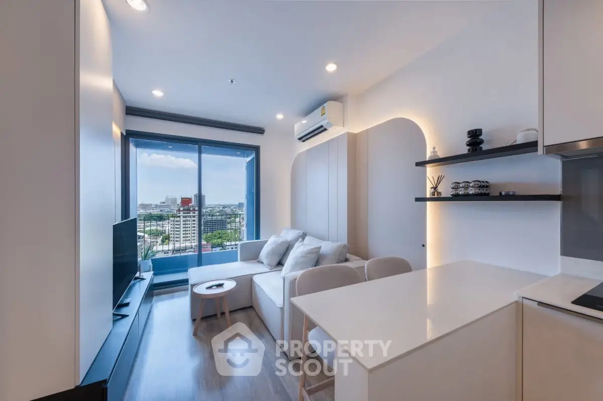 Modern living room with city view, sleek furniture, and open layout in a high-rise apartment.