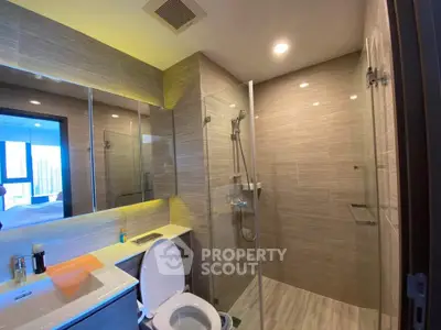 Modern bathroom with glass shower and sleek fixtures in a contemporary apartment.