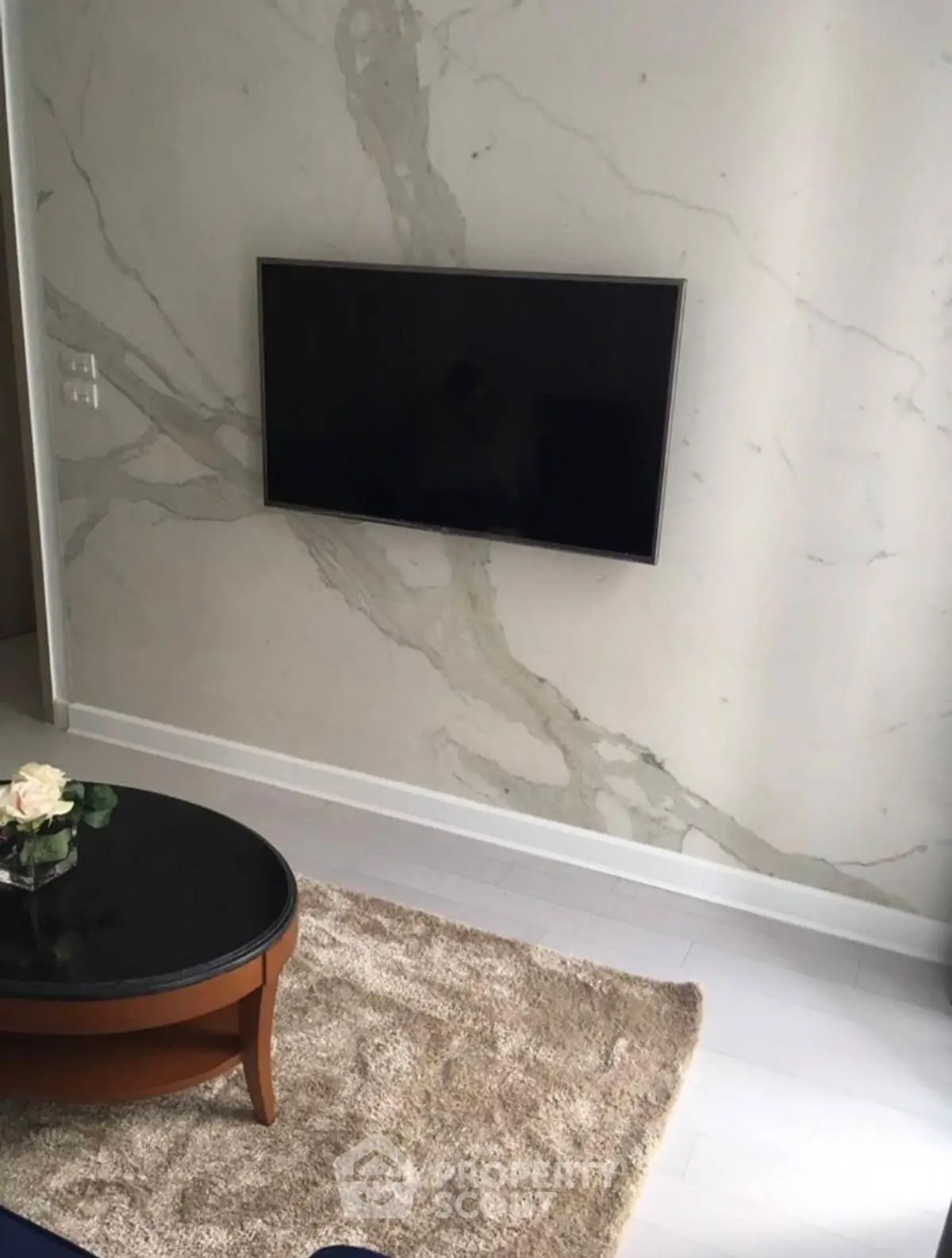 Elegant living room with marble accent wall and mounted TV