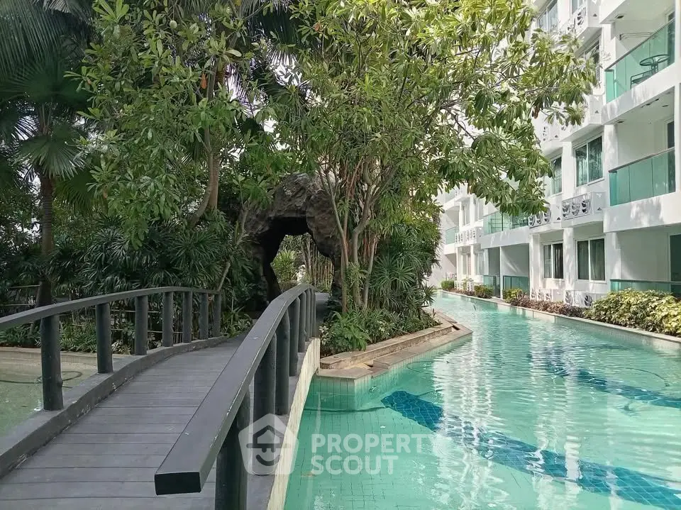 Luxurious apartment complex with serene pool and lush greenery for a tranquil living experience.